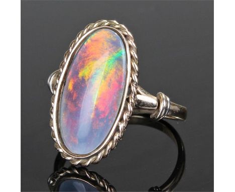 Yellow metal opal set ring, the oval opal with rope twist border, ring size T 1/2