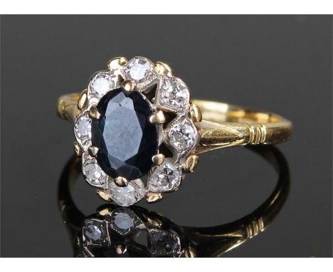 18 carat gold sapphire and diamond ring, the central sapphire with diamond surround, ring size K