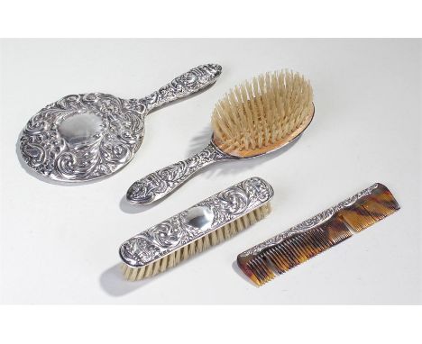 Elizabeth II silver vanity set, Birmingham 1955, with leaf scrolls and mask embossed decoration, to include the mirror, two b