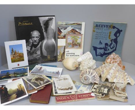 A collection of ephemera including a Picasso Christie's catalogue, postcards, photographs, books and seven sea shells 