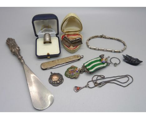 A collection of silver including a penknife, a thimble, a shoe horn with silver handle, a pair of cufflinks, a bracelet, a si