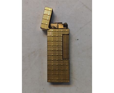 A vintage Dunhill gold plated cigarette lighter having textured design Location: 