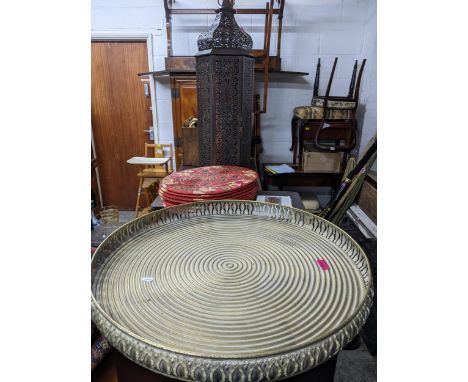 A contemporary outdoor metal Moroccan hurricane candle lantern, a large circular brass Middle Eastern style gallery tray, and