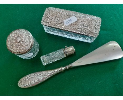 Four early 20th Century dressing table items to include a silver handled shoe horn and 2 silver topped cut glass trinket pots