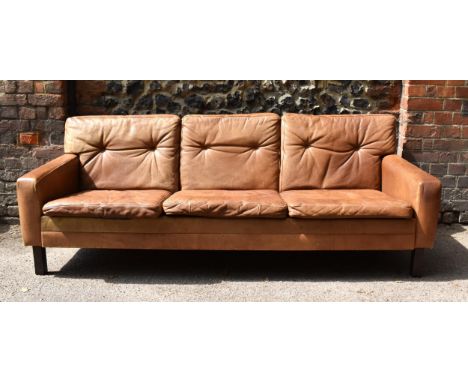 A mid century design three-seater brown leather sofa, in the style of Georg Thams, with buttoned back cushions, 69 m high x 2