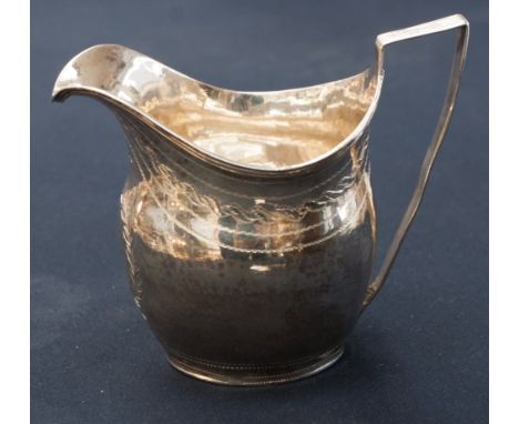 A Georgian silver helmet shaped cream jug, bright cut engraved, London 1804