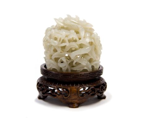 A finely reticulated official's hat finial, Qing Dynasty, of oblong section, the greyish pale green jade carved with a dragon