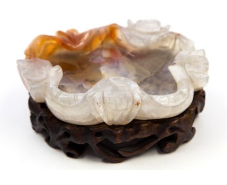 A Chinese carved jade dish, with russet inclusions, on a carved hardwood stand, together with a white jade ring, 10cm 