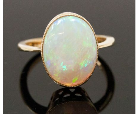 A single stone ring set with an oval blue/green boulder opal, test as 18ct 