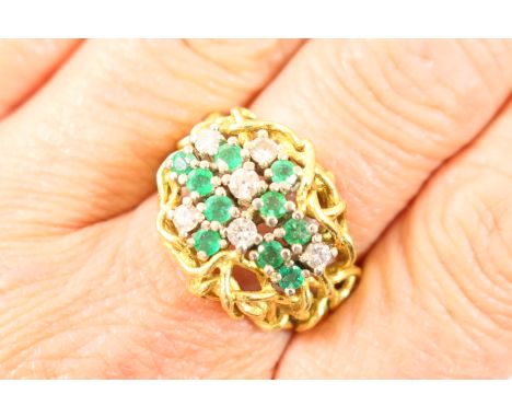 Emerald and diamond cluster ring, in the manner of Andrew Grima, probably mid 1970s, set with ten round cut emeralds and six 