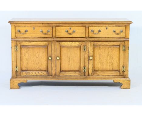 Oak enclosed dresser in the Georgian style, 20th Century, fitted with three frieze drawers with metal swan neck handles, over
