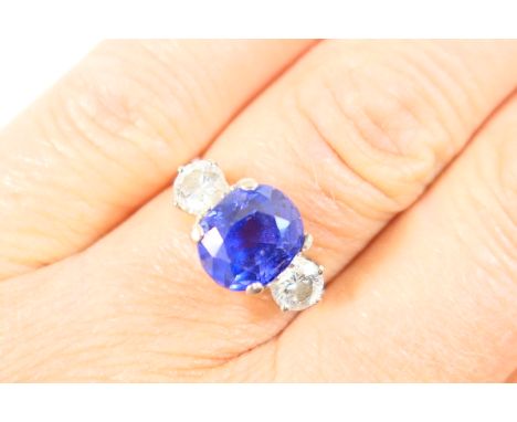 Tanzanite and diamond three stone ring, the oval cut stone of approx. 2cts, 9mm x 8mm, in a four claw mount flanked on either