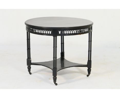 Victorian ebonised centre table, circa 1885, circular top with an arcaded pierced frieze, raised on cluster column supports w