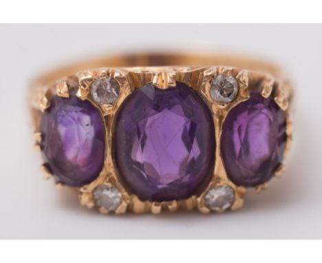 An 18ct gold, amethyst and diamond seven-stone ring: with graduated, oval amethysts between circular diamond points. 