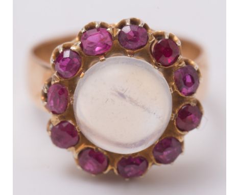 A moonstone and ruby cluster ring:, the circular moonstone within a surround of circular and oval-cut rubies, ring size M 1/2
