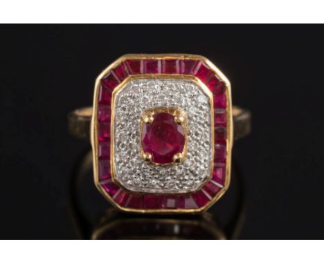 A modern 18ct gold, ruby and diamond mounted rectangular cluster ring: with central oval ruby 5.0mm. long x 4.2mm. wide, claw