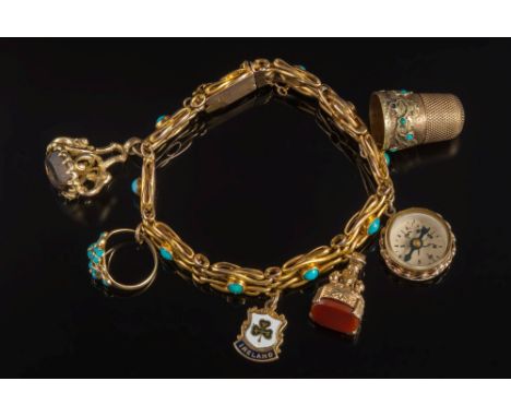 A 9ct gold and turquoise mounted bracelet: with six various attached gold charms including a Victorian gold and turquoise eng