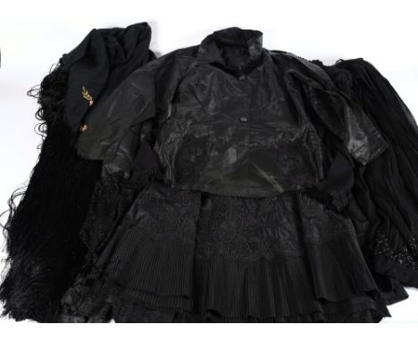 Two black silk overskirts, a black silk petticoat, blouse, shawl, together with a black crepe blouse and skirt:. 