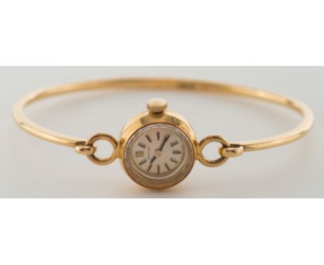 Certina. A lady's 18ct gold bangle wristwatch:, the circular satin-finish dial with baton markers.