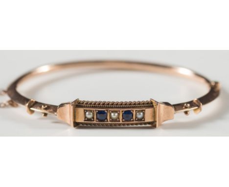 A Victorian gold, sapphire and seed pearl hinged bangle:, with fitted, blue velvet case. 