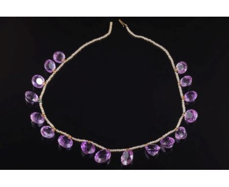 An early 20th century amethyst and seed pearl fringe necklace: with seventeen round and oval amethysts graduated from 10mm to