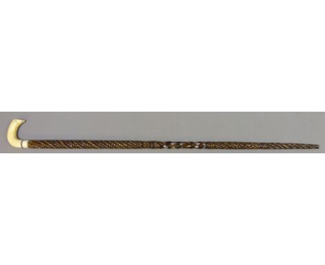 Carved wooden walking stick, rope twist facet and plait carved shaft with with walrus ivory carved handle, L96cm