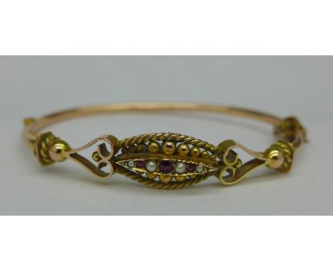 A 9ct gold, ruby and seed pearl bangle, 6.3g