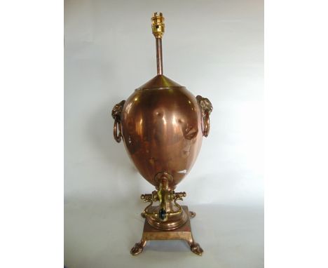 A 19th century copper samovar of baluster form raised on a squared base with bacchanalian supports, flanked by looping handle