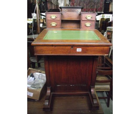 A Victorian mahogany davenport, the raised back (possibly associated) presented as four small drawers flanking an open shelf 