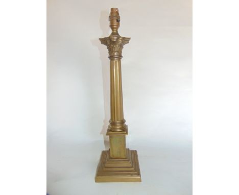 A brass desk lamp in the form of a fluted column with Corinthian capital, raised on a squared stepped blockade base, 48 cm ta