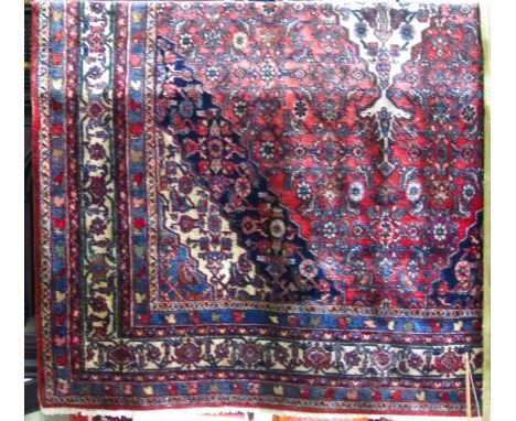 A Persian wool carpet, in the Hamedan manner, the central pink ground with a white central medallion interspersed with compli