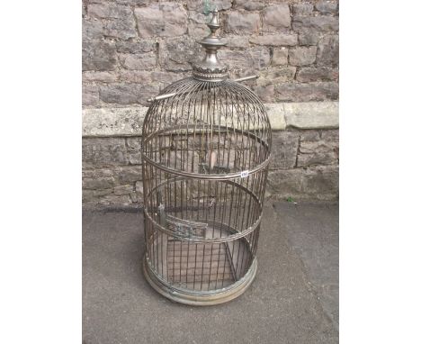 A large bird cage of cylindrical and domed form with raised finial and decorative detailing