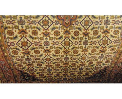 A Persian style brushed woodwork carpet with abstract floral detail upon a white field within pale plum ground and running bo