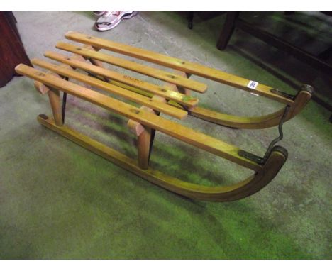 A vintage wooden toboggan, with slatted seat and iron fittings (transfer label Hohnberg Rodel)