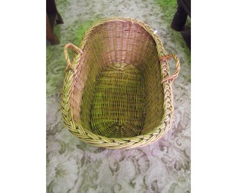 A vintage wicker baby basket, with loop handles
