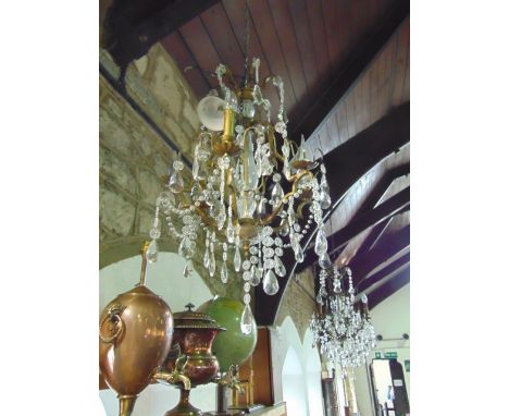 A decorative contemporary six branch electrolier with hanging clear cut droplets, with gilt effect framework and further fini