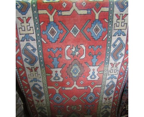 An eastern wool work carpet with terracotta field interspersed with geometric motifs contained within a cream and further tra