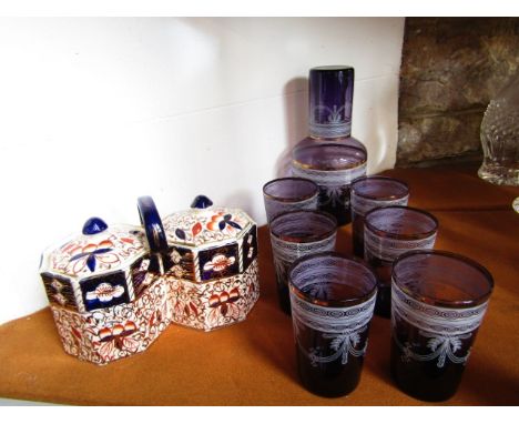 An amethyst glass carafe together with seven associated beakers, all with gilded rims and further enamelled detail, loosely i