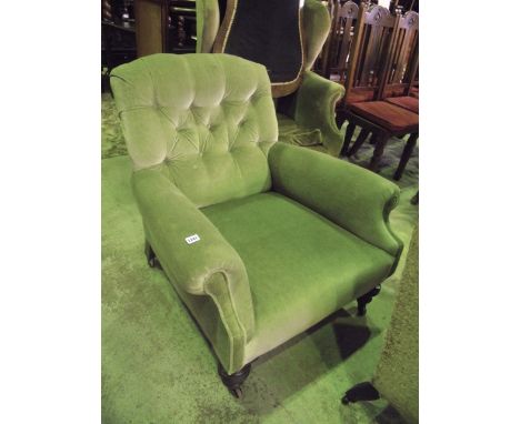A late Victorian/Edwardian low deep seated easy chair with rolled arms, green dralon upholstered with button back and raised 