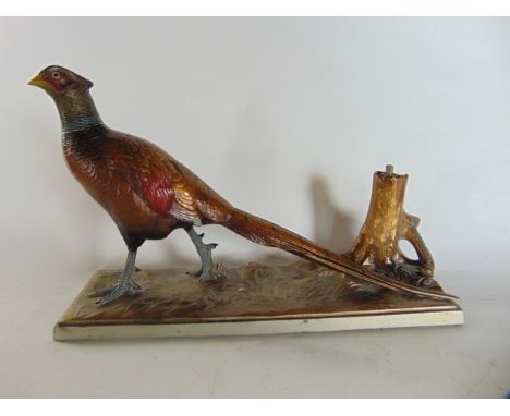 A 20th century table lighter in the form of a strolling cock pheasant beside a tree stump, with naturalistically painted fini