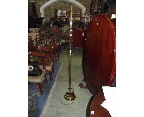 A polished brass standard lamp with partially knopped stem and domed disc shaped platform base