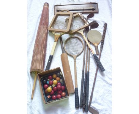 A collection of vintage golf clubs, timber tennis rackets, a large painted parasol, etc