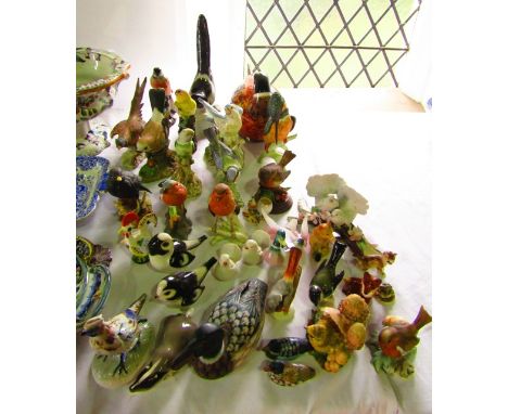 A quantity of ceramic models of birds including examples by Goebel including a kingfisher, robin, pheasant, USSR magpie, etc,
