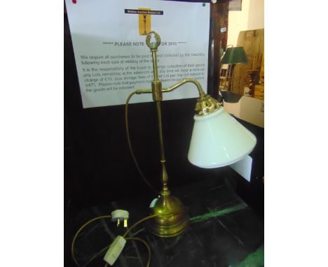 An adjustable brass table lamp, with milk glass shade and domed disc shaped base