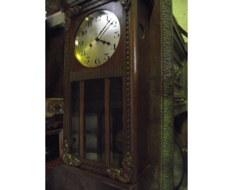 An oak cased wall clock with circular silvered dial and applied moulded detail together with an early 20th century oak grandm