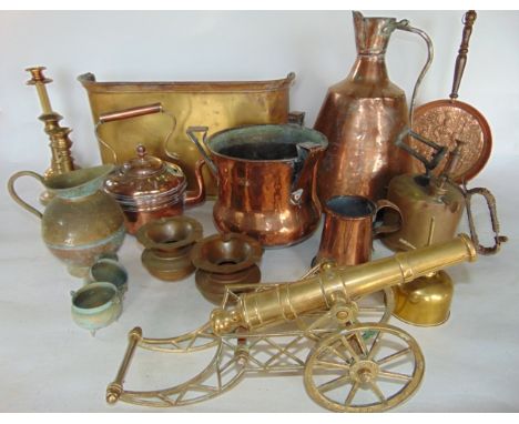 A collection of antique metal wares to include a large copper vessel with looping handle, a brass model of a cannon, a small 