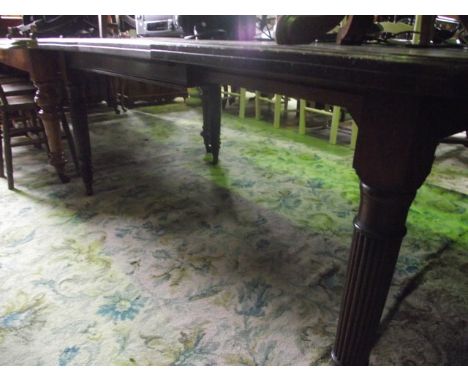 An Edwardian walnut wind-out extending dining table of rectangular form with moulded outline and rounded corners, single addi