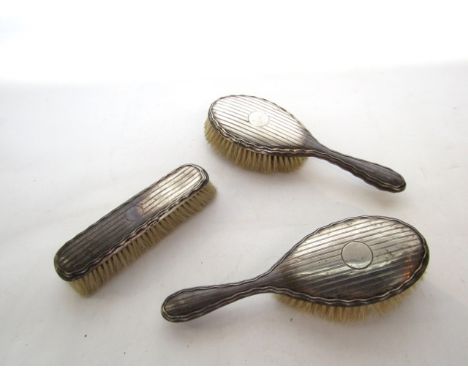 A George V silver dresser set, W.G. Sothers & Co., Birmingham, 1942 & 1945, comprising: two hairbrushes and a clothes brush, 