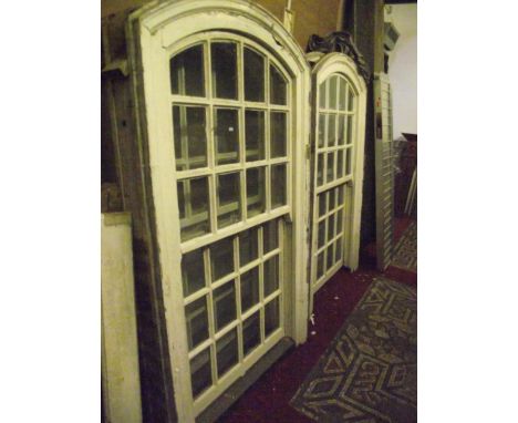 A set of four reclaimed Georgian sash windows of arched form with painted pine frames and segmented moulded glass framed pane