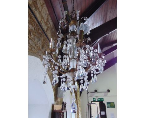 A decorative contemporary six branch electrolier with hanging clear cut droplets, with gilt effect framework and further fini
